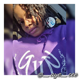 Bourgeois Pineapples owner Ayesha Clarke wearing red white and blue love Obama wood earrings featuring photo of United States 44th President Barack Obama. She is wearing purple hoodie from the Grindn 2 Greatness collection. Grindn2GreatnessEnt