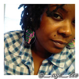 Bourgeois Pineapples owner Ayesha Clarke wearing black circle wood fashion earrings with African American art woman and pink and green writing saying I am stronger than you believe braver than you know smarter than you think